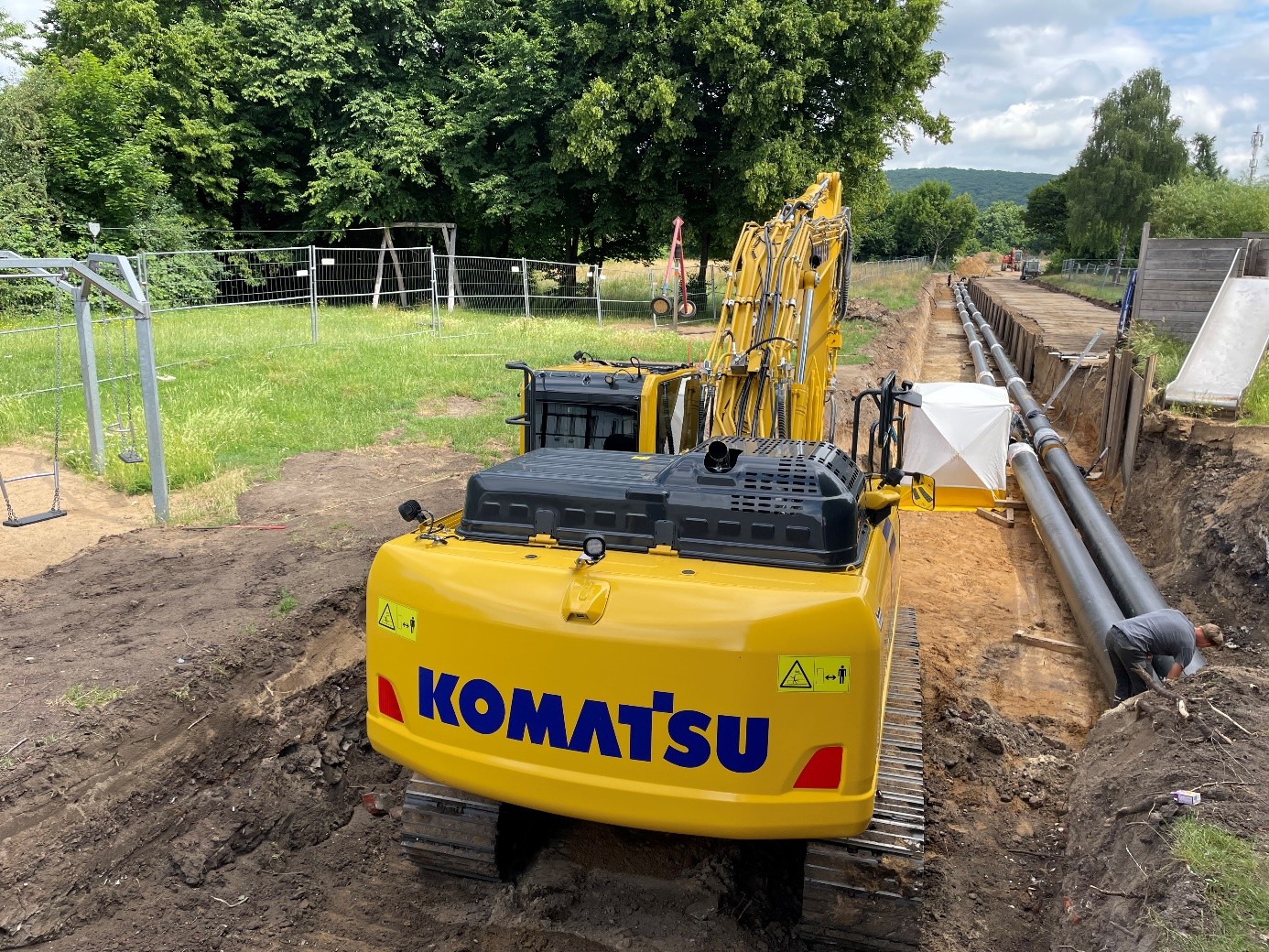 Ein Bagger steht vor einem offenen Graben neben dem Spielplatz Ziegelstraße.