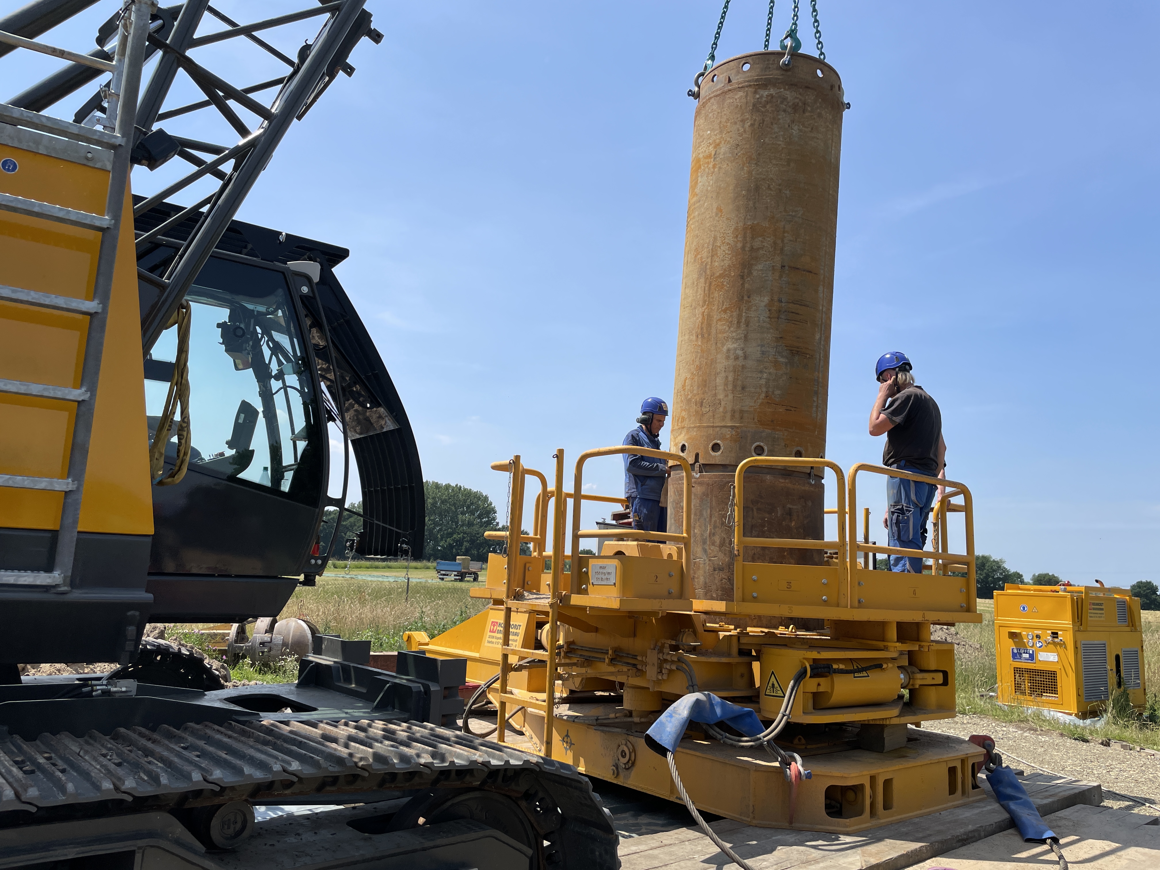 Brunnenrohr zur Trinkwassergewinnung wird mit einem Kranwagen eingelassen.