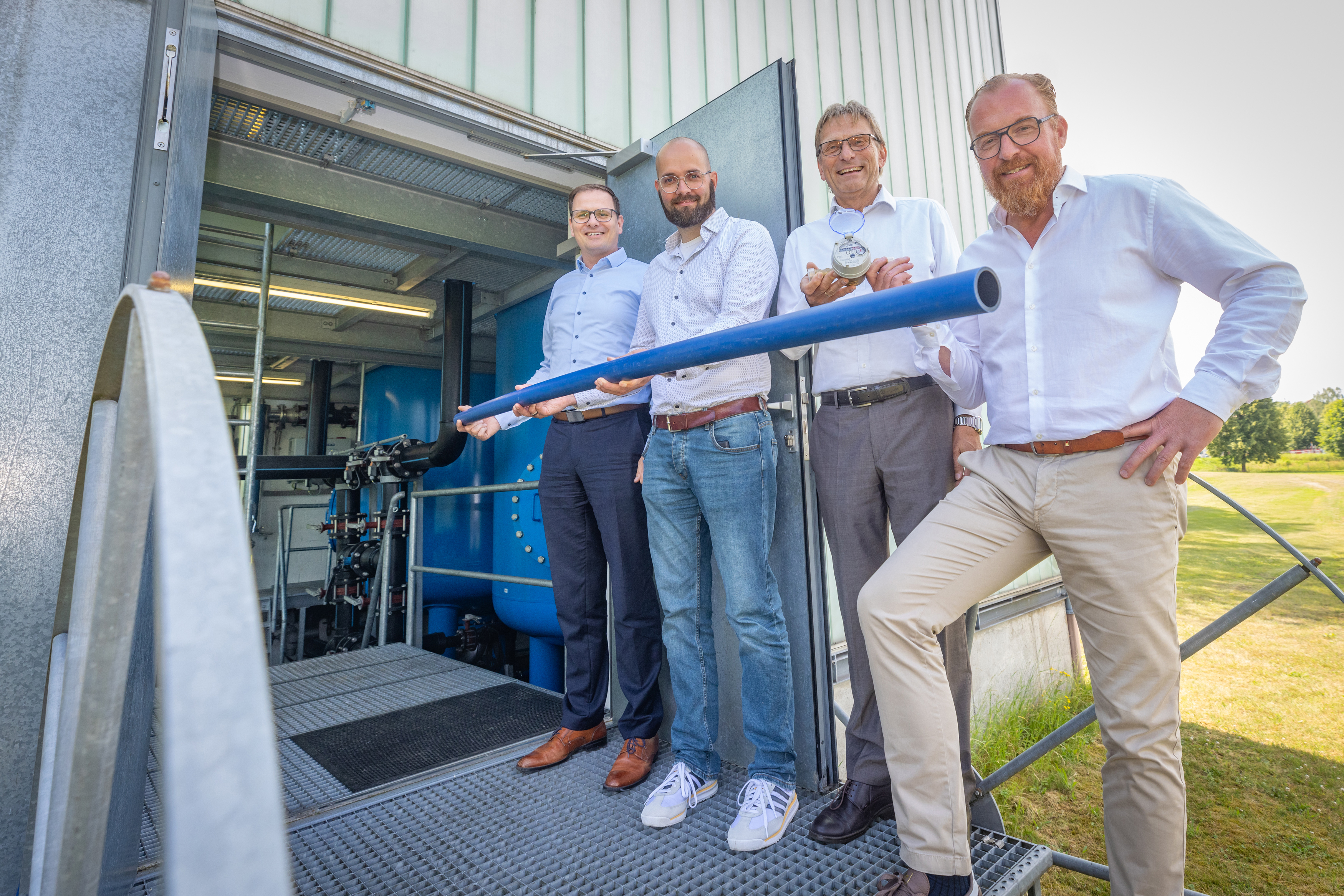 Die Stadtwerke Geschäftsführer Matthias Sasse (Lemgo), Michael Benneker (Oerlinghausen), Jörg Karlikowski und Volker Stammer (Bad Salzuflen) werben für Wassersparen und präsentieren dazu ein Rohr und einen Zähler.