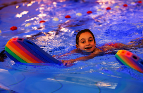 Mädchen mit Schwimmbrett im Wasser
