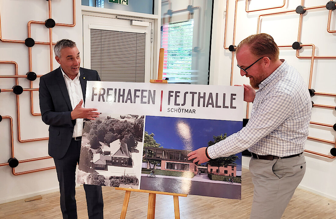 Volker Stammer und Dirk Tolkemitt präsentieren das neue Logo der Festhalle Schötmar im Netzwerk an der Uferstraße.