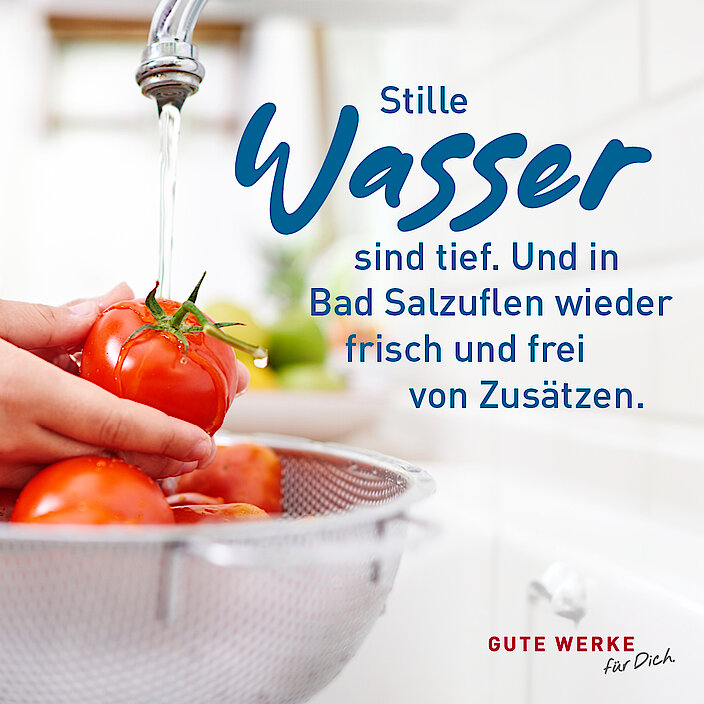 Person wäscht unter Wasserhahn Tomaten