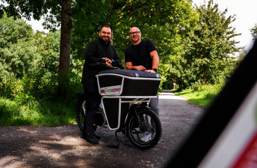Zwei Personen stehen neben einem Lastenrad