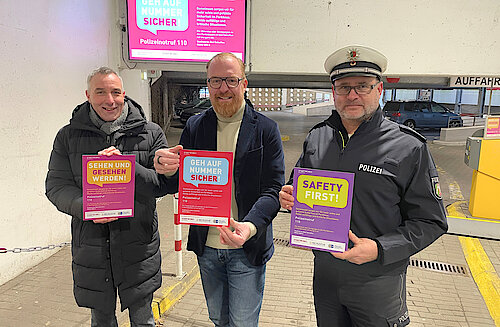 Bürgermeister Dirk Tolkemitt, Stadtwerke Geschäftsführer Volker Stammer und erster Polizeihauptkommissar Marc Krumsiek präsentieren die neue Sicherheitskampagne im Parkhaus Zentrum.