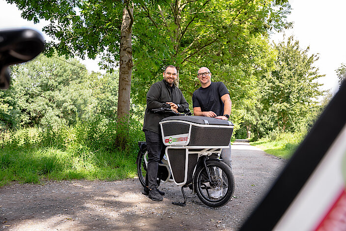 Zwei Personen mit einem Lastenrad