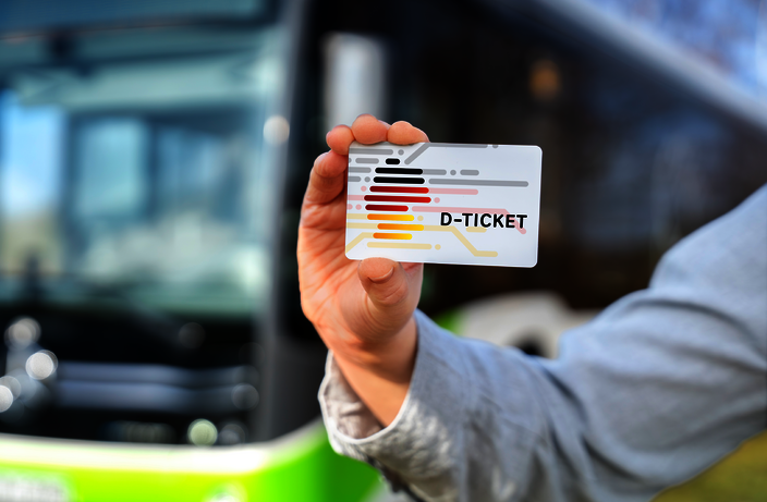 Person zeigt D-Ticket vor einem Bus
