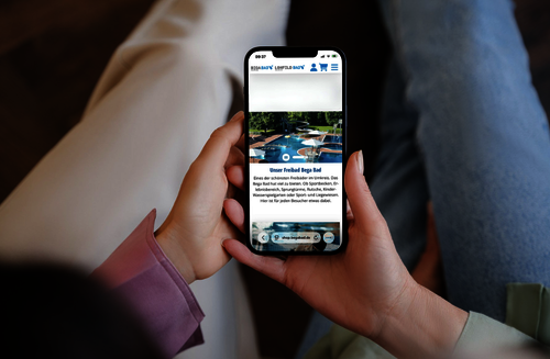 Zwei Personen halten ein Handy in der Hand