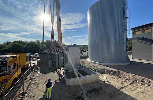 Auf der Baustelle an der Ziegelstraße wird ein Transformator wird per Kran in die Trafostation gehoben