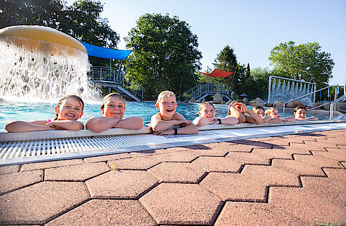 Kinder am Beckenrand im Freibad